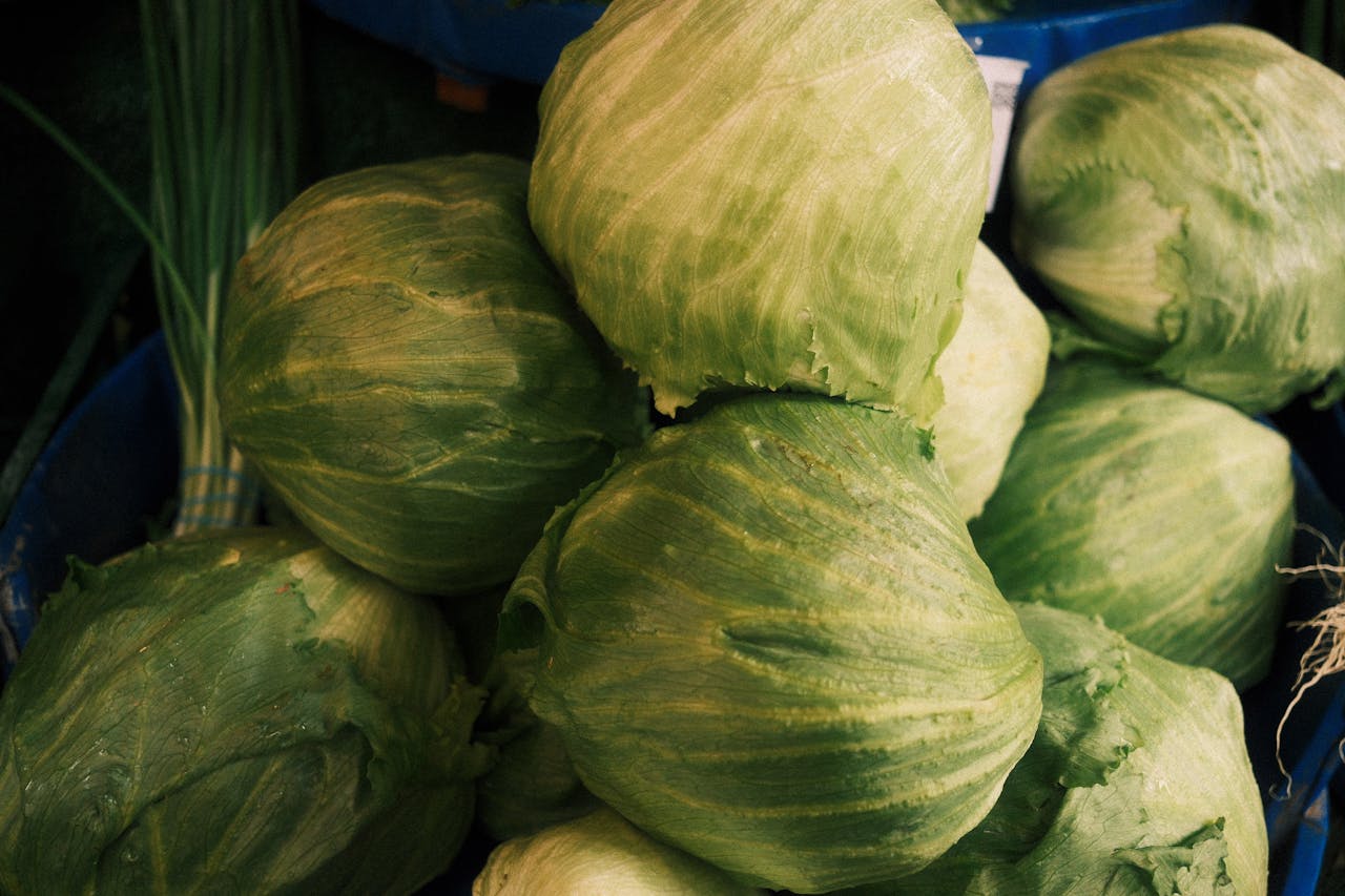 home-hero A stack of fresh green cabbages displayed at an outdoor market